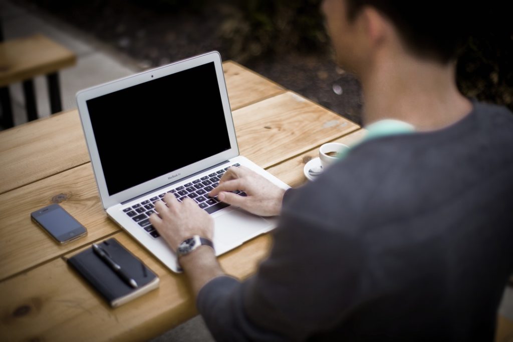 man typing on laptop