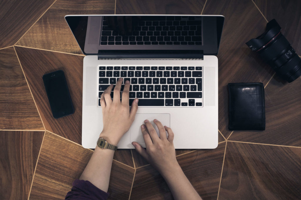 hands typing on laptop